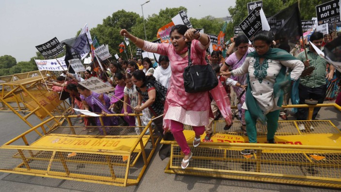 Supporters of India's main opposition BJP cross over a police barricade as they march towards residence of chief of India's ruling Congress party Sonia Gandhi during a protest rally in New Delhi