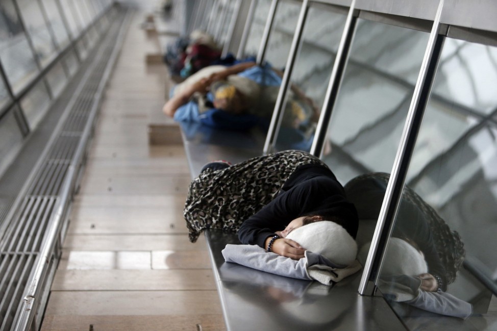 Passengers sleep in the departure hall at Israel's Ben-Gurion International Airport during a strike by airline workers