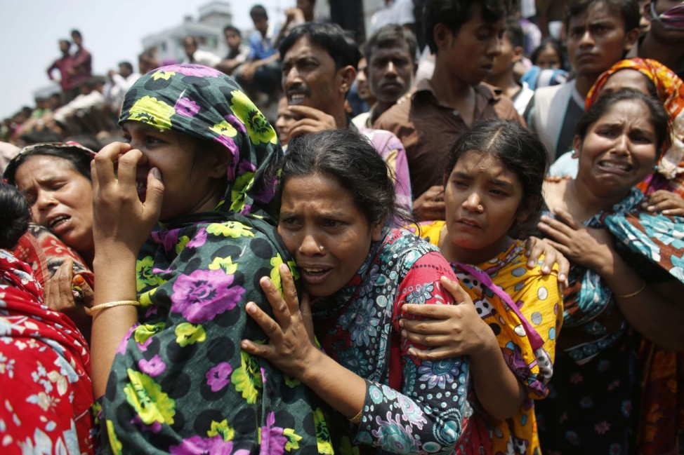 People mourn for their relatives, who are trapped inside the rubble of the collapsed Rana Plaza building, in Savar