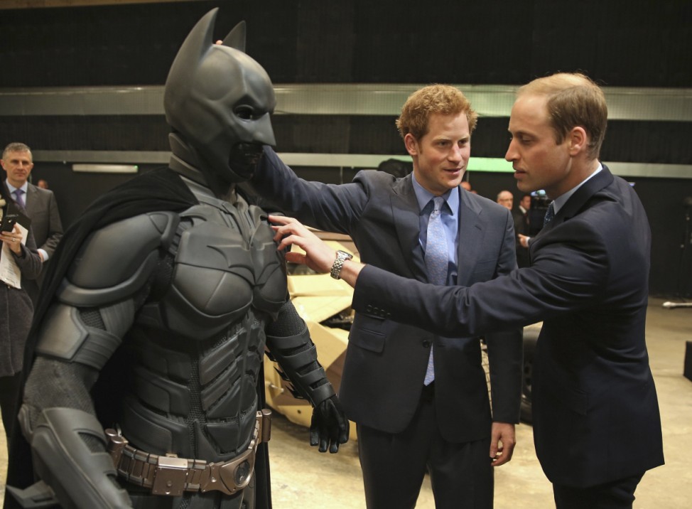 Britain's Prince William and his brother Prince Harry look at a 'batsuit' during their visit to the Warner Bros. Studios at Leavesden in southern England