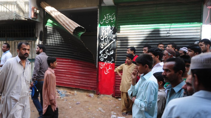 Vor Parlamentswahl: Schaulustige versammeln sich in Karachi vor einem Parteibüro, wo kurz zuvor eine Bombe explodiert war.