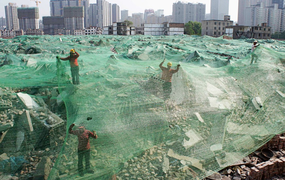 Workers set up dust screen on a demolition site in Xi'an
