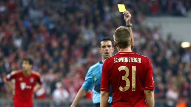 BBayern Munich's Schweinsteiger is shown yellow card by referee Kassai during Champions League semi-final first leg soccer match again Barcelona  in Munich