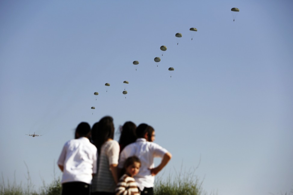 Ultra-Orthodox Jewish children watch as Israeli paratroopers take part in a military exercise at the Palmachim air force base near Tel Aviv