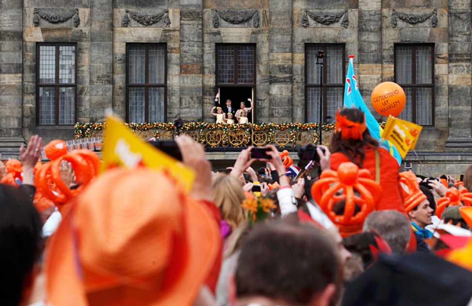 Dutch King Willem-Alexander and his wife Queen Maxima wave to the crowd from the balcony of the Royal Palace in Amsterdam