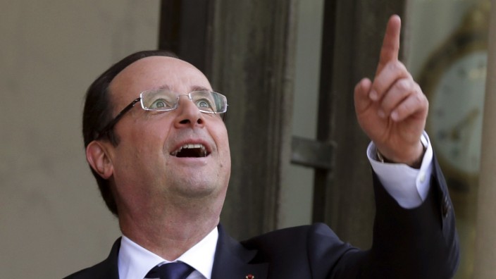 French President Francois Hollande points at the sky at the Elysee Palace in Paris