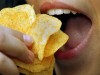 Junge Frau isst Kartoffelchips