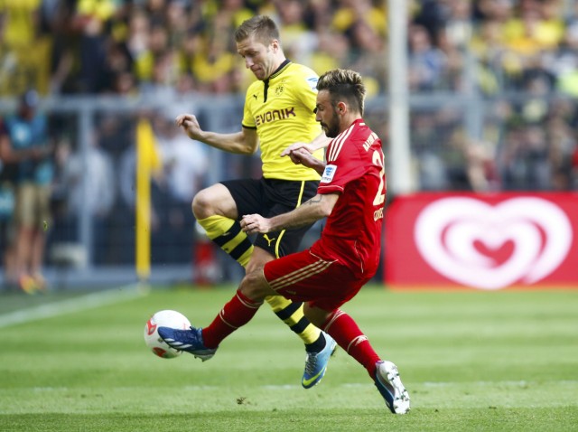 Bayern Munich's Contento fights for the ball with Borussia Dortmund's Blaszczykowski during their German first division Bundesliga soccer match in Dortmund