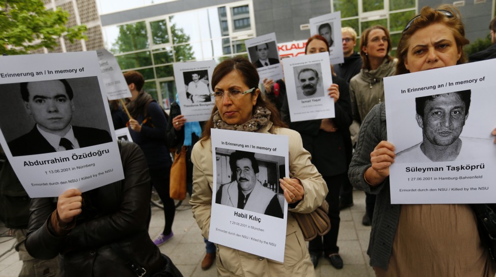 Protesters hold pictures of victims outside a courthouse, where the trial against Beate Zschaepe, a member of the neo-Nazi group National Socialist Underground (NSU), will start later today, in Munich