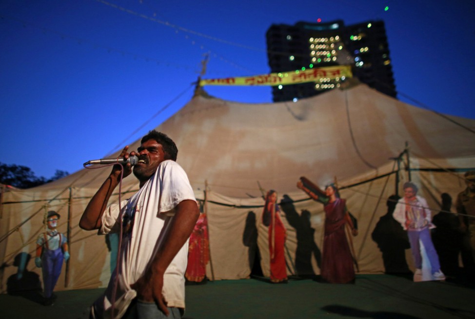 Employee of Anoop Touring Talkies, a travelling tent cinema company, speaks into a microphone to advertise a film in Mumbai