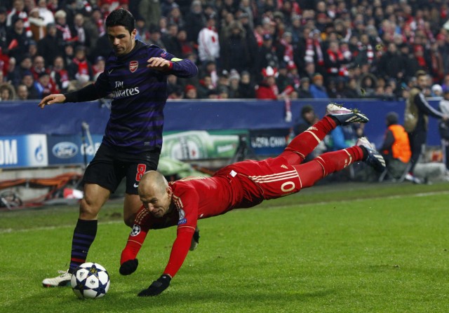 Bayern Munich's Robben dives next to Arsenal's Arteta during their Champions League round of 16 second leg match in Munich
