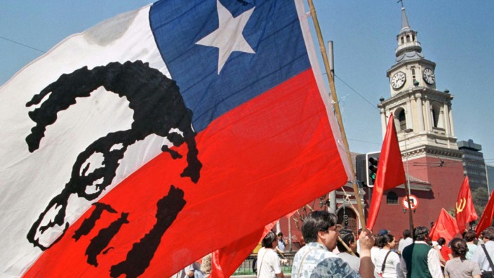 MAN WITH CHILEAN FLAG AND SALVADOR ALLENDES IMAGE