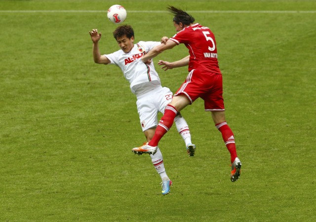 Bayern Munich's van Buyten competes with Augsburg's Ji Dong-Won during their German first division Bundesliga soccer match in Munich