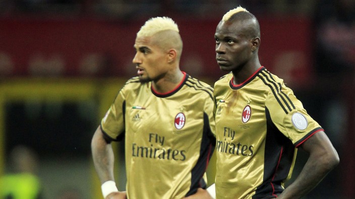 AC Milan's Boateng and Balotelli look on as referee Rocchi suspends the match due to racist chants during their Italian Serie A soccer match against AS Roma in Milan