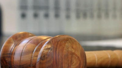 Prozess gegen Oliver Shanti: Ein hölzerner Hammer liegt auf der Richterbank in einem Verhandlungssaal.