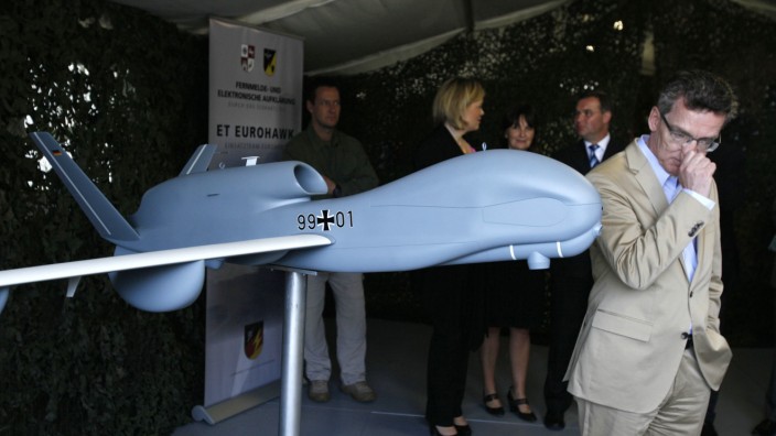 German Defence Minister de Maiziere stands next to model of a Euro Hawk drone at Joint Support Service base in Grafschaft