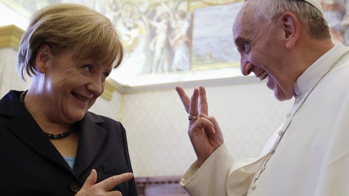 Pope Francis gestures as he talks to German Chancellor Angela Merkel during a private audience at the Vatican