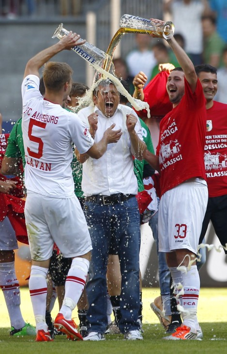 Augsburg's coach Weinzierl has beer poured over his head by Moelders and Klavan after German first division Bundesliga soccer match against Greuther Fuerth in Augsburg