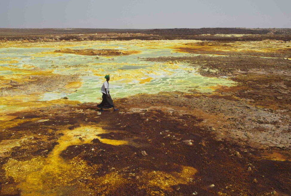 A man walks on sulphur and mineral salt formations near Dallol in the Danakil Depression