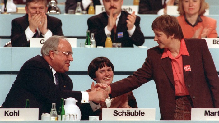 1991: Bundeskanzler Helmut Kohl gratuliert seiner neugewählten Stellvertreterin, Frauenministerin Angela Merkel, während des Parteitags der CDU am 15. Dezember 1991 im Kulturpalast in Dresden.