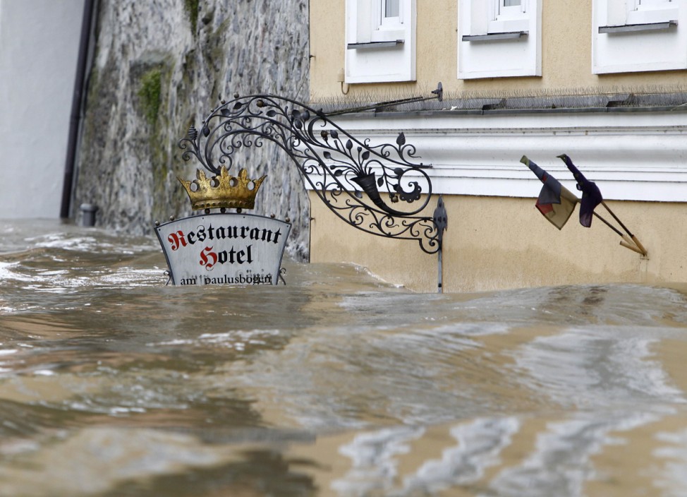 Sign for restaurant and hotel is partially submerged in flooded centre of Passau