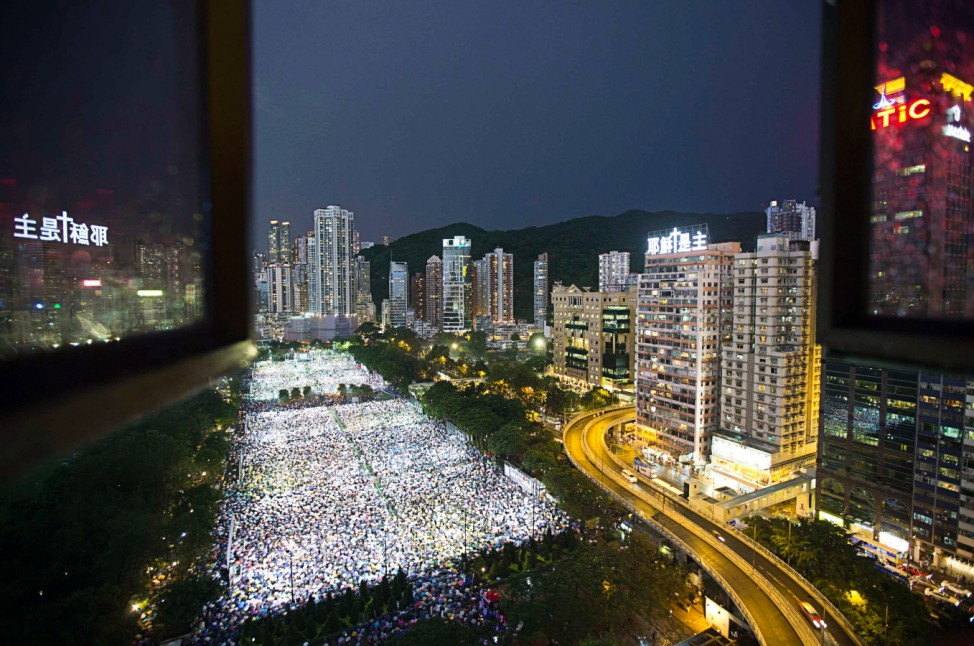 Tens of thousands of people participate in a candlelight vigil at Hong Kong's Victoria Park