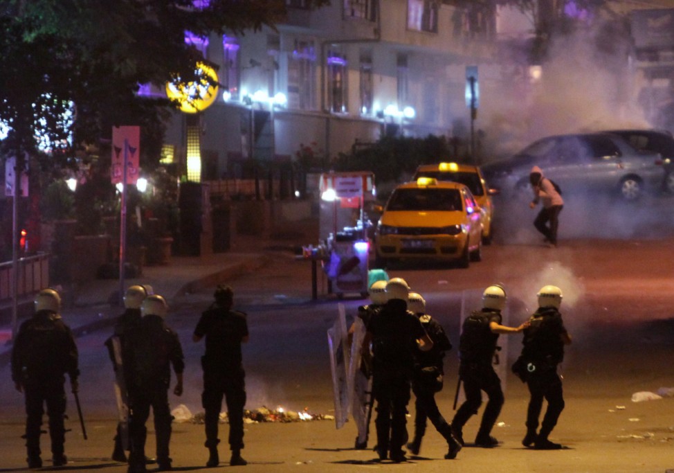 An anti-government protester throws stones at riot police in central Ankara
