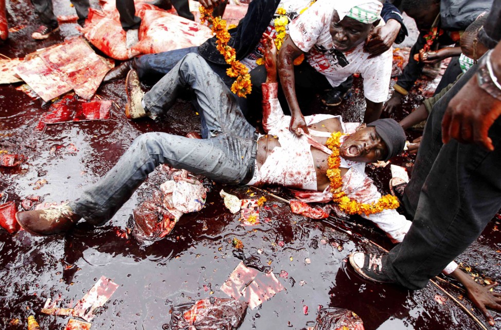A protester lies in animal blood as he participates in a demonstration against lawmakers' demands for a pay rise in Nairobi