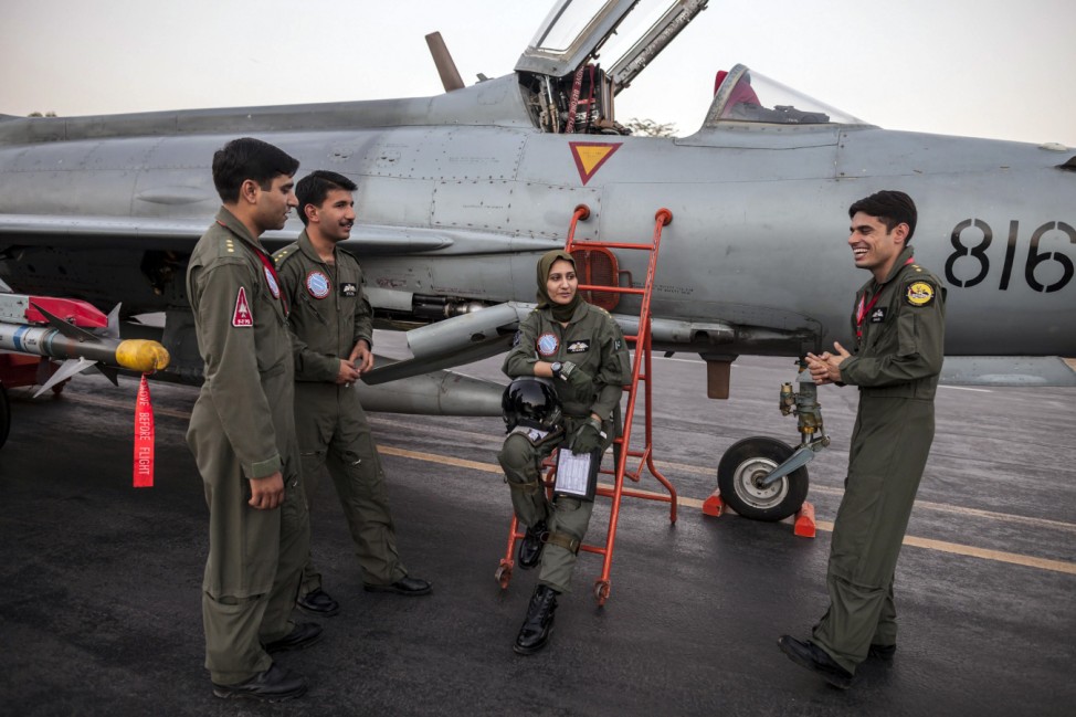 Ayesha Farooq, 26, Pakistan's only female war-ready fighter pilot, chats with her colleagues beside a Chinese-made F-7PG fighter jet at Mushaf base in Sargodha