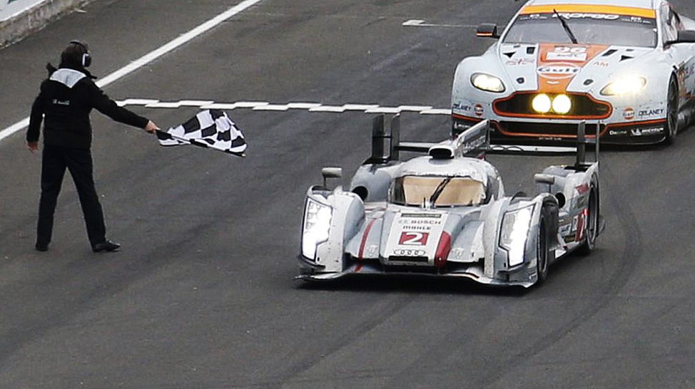 Denmark's Kristensen, driving the Audi R18 E-Tron Quattro Number 2, crosses the finish line at the Le Mans 24-hour sportscar race in Le Mans
