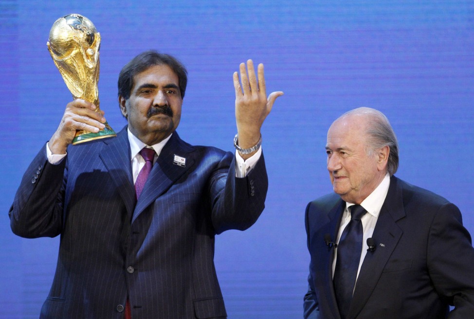Qatar's Emir Sheikh Hamad holds up a copy of the World Cup he received from FIFA President Blatter in Zurich