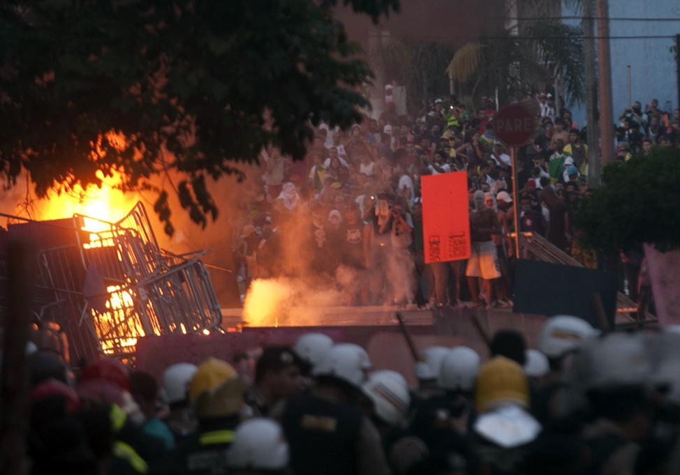 Riot police clash with demonstrators during a protest near the Mineirao Stadium in Belo Horizonte