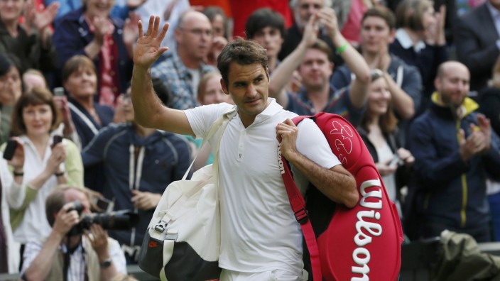 Roger Federer of Switzerland walks off the court after being defeated by Sergiy Stakhovsky of Ukraine in their men's singles tennis match at the Wimbledon Tennis Championships, in London