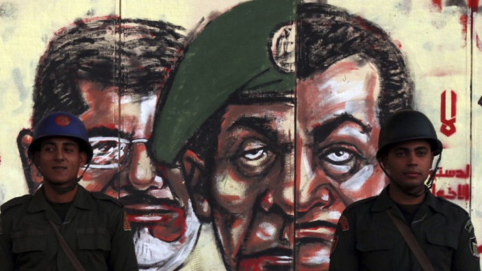 File photo of Republican Guard soldiers standing in front of a mural on the wall of the presidential palace in Cairo