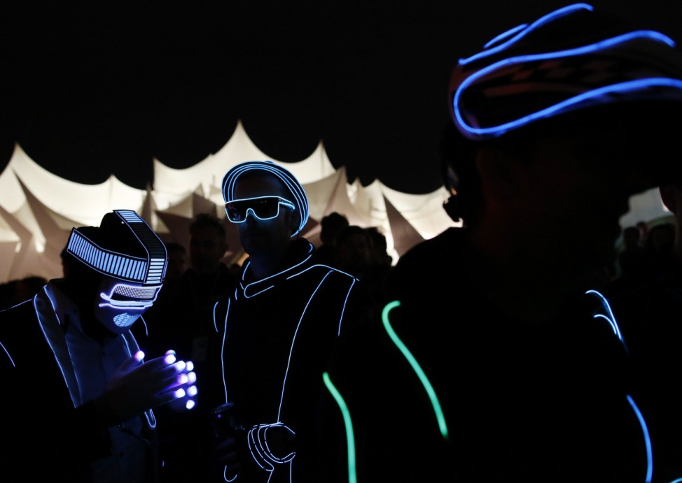 Gary Wright and Jon Williams wear light costumes in Shangri La field at Glastonbury music festival at Worthy Farm in Somerset