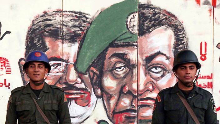 File photo of Republican Guard soldiers standing in front of a mural on the wall of the presidential palace in Cairo