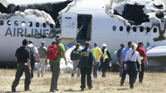 U.S. National Transportation Safety Board investigators work at the scene of the Asiana Airlines Flight 214 crash site at San Francisco International Airport in San Francisco