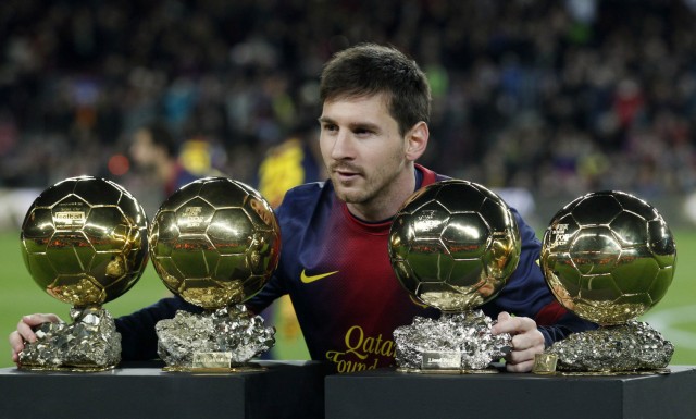 Barcelona's player Messi poses with his Ballon d'Or trophies before their Spanish King's Cup soccer match against Malaga in Barcelona