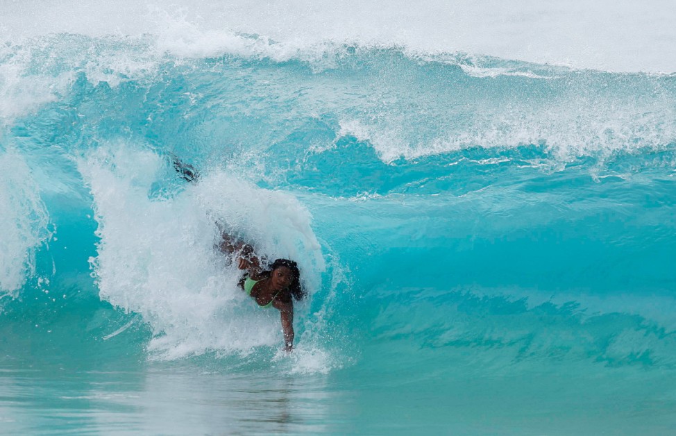 A woman bodysurfs on a wave at Sandy Beach near Honolulu