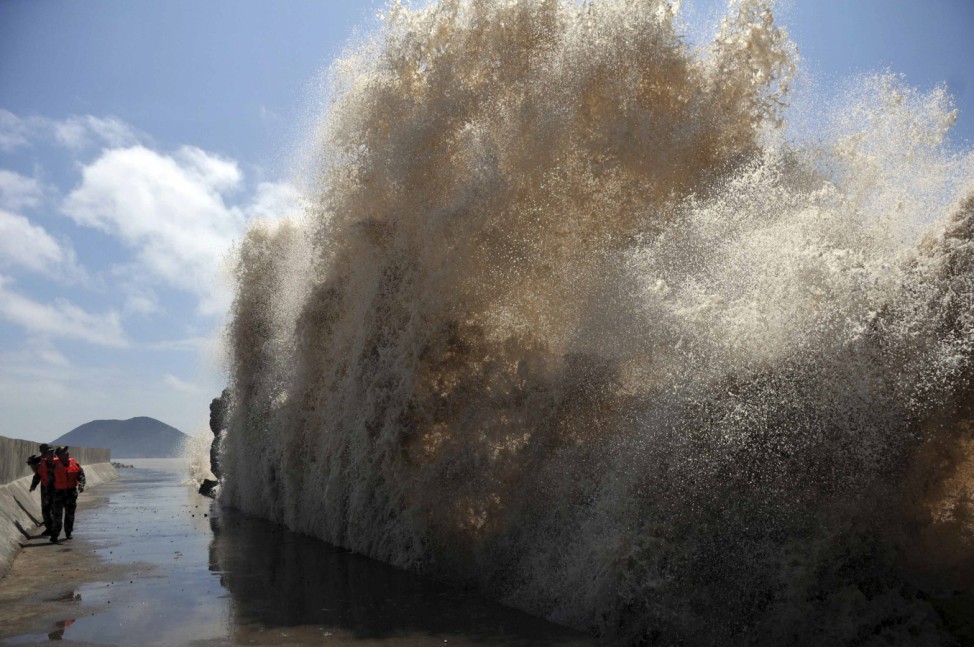 Frontier soldiers look up at the swell, as they carry out a check of a seawall, as Typhoon Soulik approaches in Wenling