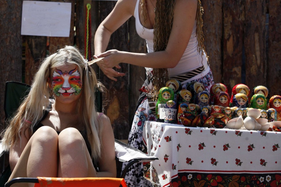A visitor has her hair styled during the 'World of Siberia' International festival of folk music and crafts in Shushenskoye