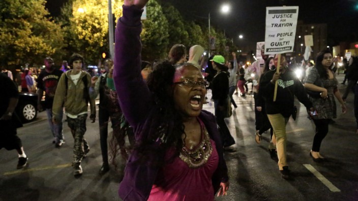 A protester marches in the Leimert Park area following the George Zimmerman verdict in Los Angeles
