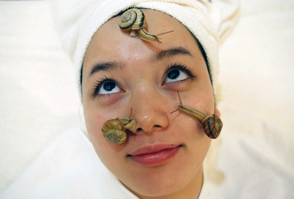 Snails crawl on the face of a woman during a demonstration of a new beauty treatment at Clinical-Salon Ci:z.Labo in central Tokyo