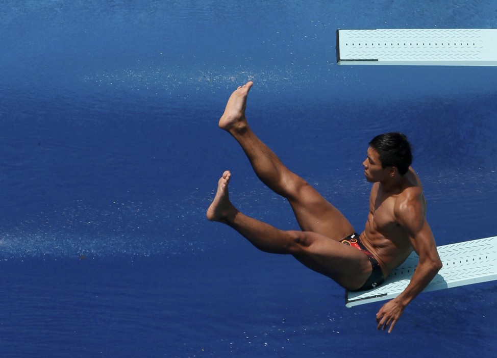 China's Sun Zhiyi slips and falls during his dive at the men's 1m springboard preliminary during the World Swimming Championships at the Montjuic municipal pool in Barcelona