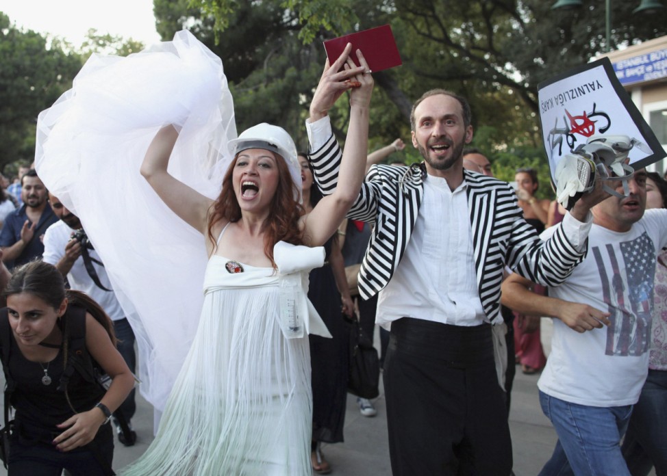 Newly married couple Nuray Cokol and Ozgur Kaya shout slogans as they visit Gezi Park after wedding ceremony in Istanbul