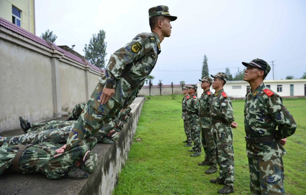 Paramilitary policemen take part in exercises, part of a psychological training programme aimed at relieving anxiety, in Chuzhou, Anhui province