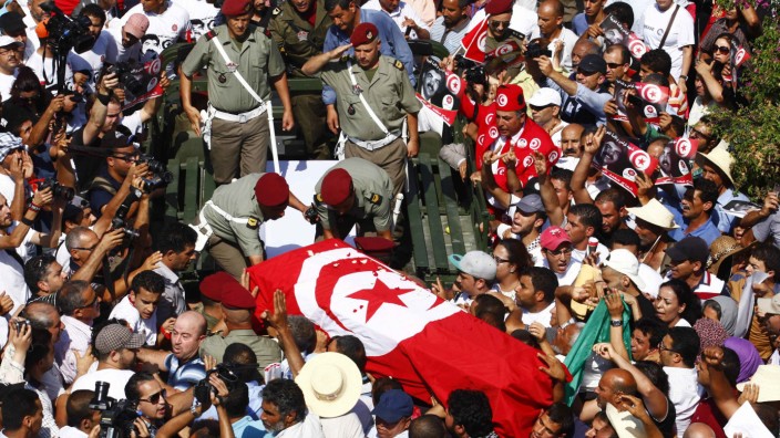 Mourners carry the coffin of slain opposition leader Brahmi during his funeral procession towards a cemetery in Tunis