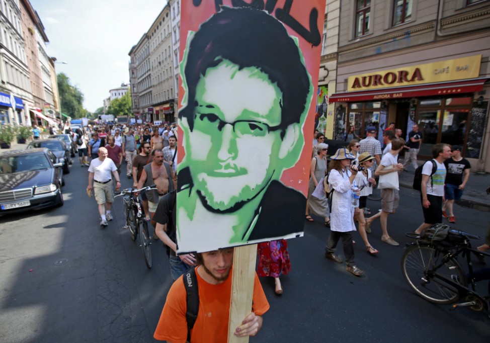 A protester carry a portrait of Snowden during a demonstration against secret monitoring programmes PRISM, TEMPORA, INDECT and showing solidarity with whistleblowers Snowden, Manning and others in Berlin
