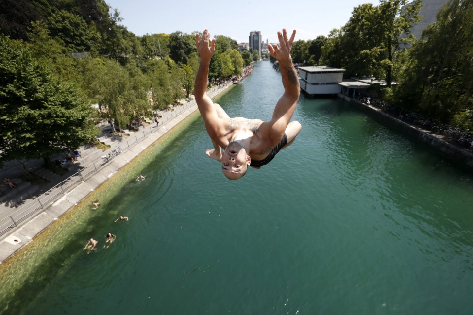 A man jumps from a bridge into the Limmat river during hot summer weather in Zurich