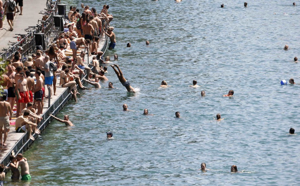 People swim in the Limmat river during hot summer weather in Zurich